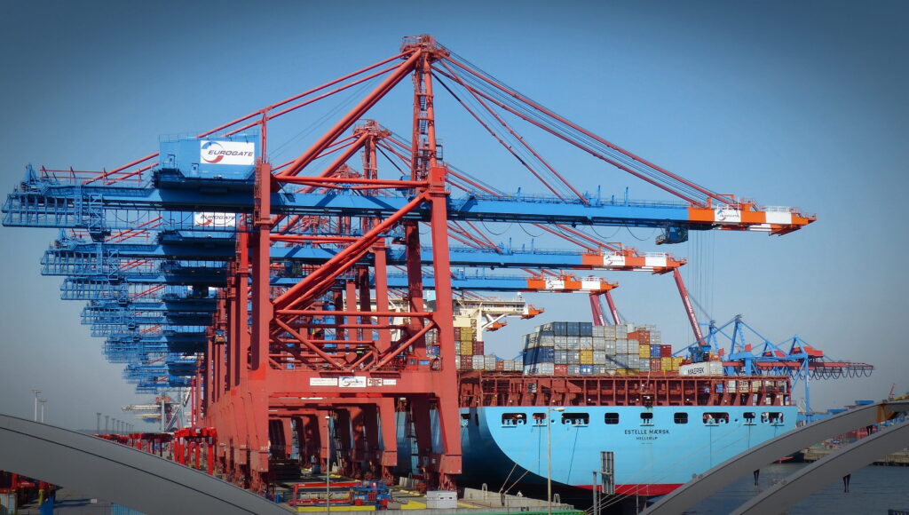 How did gigantic ships break our global supply chains? cranes at termainl to unload cargo ship