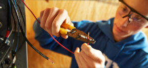 Job training: The image is of someone trimming an electrical work that inside an electrical distribution panel